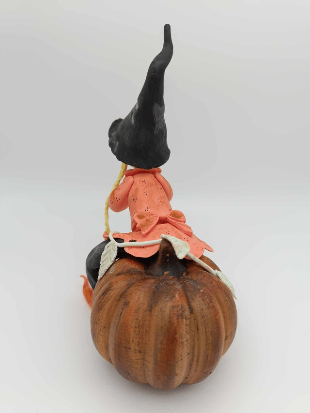 Sorcière en porcelaine froide sur citrouille